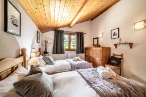 モルジヌにあるChalet Beauséjourの木製の天井が特徴のベッドルーム1室(ベッド2台付)