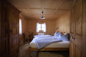 a bedroom with a bed in a wooden house at Almhütte Oberschaller bei Alfenalm - Ferienwohnungen am Berg in Innervillgraten