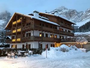 a large building in the snow with mountains in the background at Ca' del Sole in San Vito di Cadore