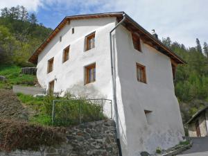a white building with windows on a hill at Holiday Home Ferienhaus Döss by Interhome in Müstair