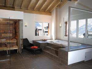 a bathroom with a tub and a glass shower at Apartment B33 by Interhome in Leukerbad