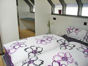 a bedroom with a bed with purple flowers on it at Holiday Home Albergo Centro by Interhome in Hüfingen