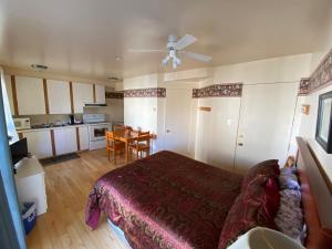 1 dormitorio con 1 cama y cocina con mesa en Les Suites de L'Anse, en Tadoussac