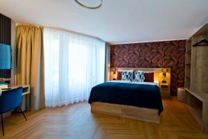 a bedroom with a bed and a large window at Atrium Hotel Amadeus in Osterfeld