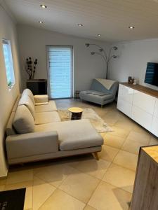 a living room with a couch and a table at Ammersee Garten Appartment in Herrsching am Ammersee