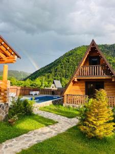 una casa de madera con un arco iris en el fondo en Eco House Borjomi en Borjomi