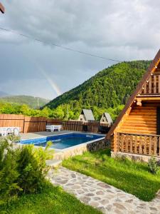 une maison avec piscine et arc-en-ciel en arrière-plan dans l'établissement Eco House Borjomi, à Bordjomi