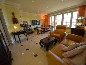 ein Wohnzimmer mit einer Couch und Stühlen und einem Tisch in der Unterkunft Apartment Sonnenkamp-2 by Interhome in Groß Zicker