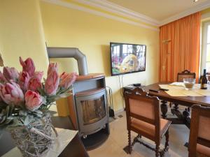 ein Wohnzimmer mit einem Kamin, einem Tisch und einem TV in der Unterkunft Apartment Sonnenkamp-2 by Interhome in Groß Zicker