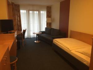 a hotel room with a bed and a couch at Hotel Görres in Wachtberg