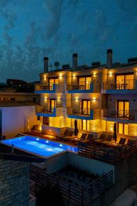 a building with a swimming pool in front of it at Perdika Ionion Villas in Perdika