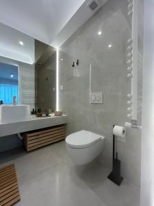 Un baño blanco con inodoro y lavabo. en Luxury residence, en Voluntari