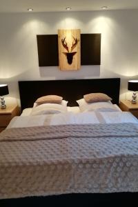 ein Schlafzimmer mit einem großen weißen Bett mit zwei Lampen in der Unterkunft Apartment Ehinger by Interhome in Eisenbach