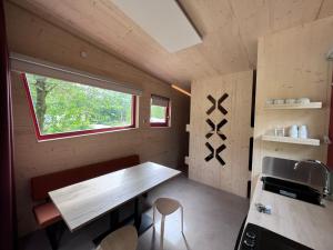 una pequeña cocina con mesa en una casa pequeña en Camping Vliegenbos en Ámsterdam