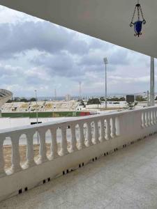 a white railing on a bridge with a view of a stadium at Apartment with amazing view in Bizerte