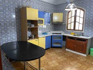 a small kitchen with a black table and blue cabinets at Apartment with amazing view in Bizerte