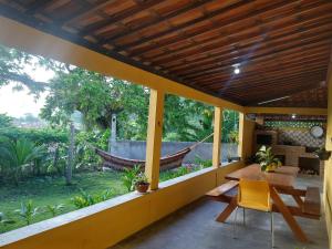 a porch with a hammock and a table and chairs at Chalé Santa Rita in Bonito