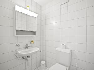 ein weißes Bad mit einem WC und einem Waschbecken in der Unterkunft Apartment Moser by Interhome in Churwalden