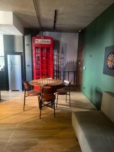 cabina de teléfono roja en una habitación con mesa en Apto Londrina Flat Hotel jacuzzi 43 m2 en Londrina