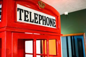um brinquedo de cabine telefónica vermelha com as palavras telefone em Apto Londrina Flat Hotel jacuzzi 43 m2 em Londrina