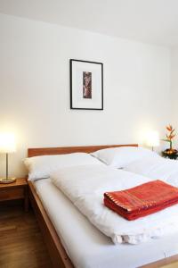 Una cama blanca con una manta roja. en Apartment Iris A-1 by Interhome en Leukerbad