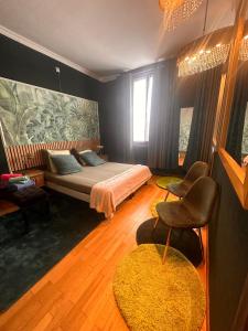 een slaapkamer met een bed en een bank en stoelen bij Le Chateau De Frankie spas-saunas in Grand-Reng - Erquelinnes