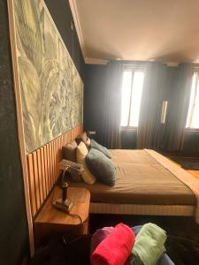 een slaapkamer met een bed met kussens erop bij Le Chateau De Frankie spas-saunas in Grand-Reng - Erquelinnes