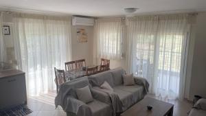 a living room with a couch and some windows at Elena M Fanari in Fanari