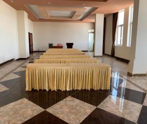 uma fila de mesas num quarto grande com uma saia de mesa em HOÀNG GIA BẠC LIÊU em Bạc Liêu