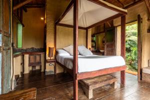 ein Schlafzimmer mit einem Himmelbett in einem Zimmer in der Unterkunft Cabañas en la montaña Viga Vieja in San Peregrino