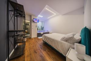ein Schlafzimmer mit einem Bett und einem TV in der Unterkunft Palazzo “Di Palma” Bed & Breakfast in Monte SantʼAngelo