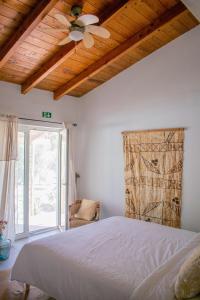 una camera da letto con un letto e un ventilatore a soffitto di Quinta Alcarias a Santa Catarina da Fonte do Bispo