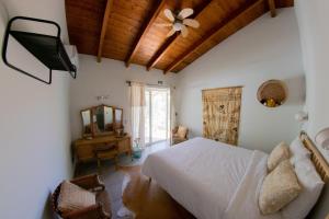 una camera da letto con un letto e un ventilatore a soffitto di Quinta Alcarias a Santa Catarina da Fonte do Bispo