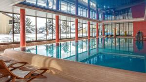 una piscina en un edificio con una ventana grande en Dorint Blüemlisalp Beatenberg/Interlaken en Beatenberg