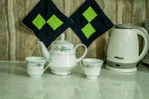 a group of tea pots and cups on a table at The KANDY DOWNTOWN Maroon House in Katugastota