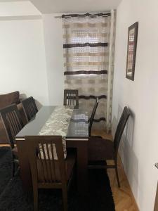 a dining room table and chairs in a room at Centar Apartment in Kumanovo +1 photo