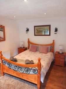 a bedroom with a wooden bed with two night stands at Eddie's Roadside Thatched Cottage 