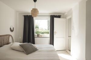 1 dormitorio con 1 cama blanca y ventana en Hygge Hus - b46378 en Hemme