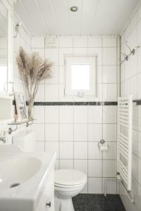 Baño blanco con aseo y lavamanos en Hygge Hus - b46378 en Hemme