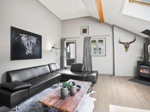 ein Wohnzimmer mit einem Ledersofa und einem Tisch in der Unterkunft Apartment Honegger by Interhome in Churwalden