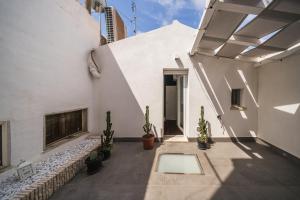einen Innenhof eines weißen Gebäudes mit Topfpflanzen in der Unterkunft Palazzo “Di Palma” Bed & Breakfast in Monte SantʼAngelo