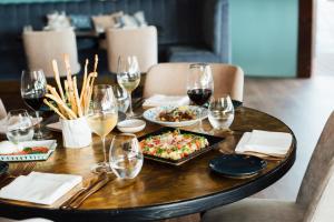 a table with a plate of food and glasses of wine at Wine & Books by the Sea, Algarve Resort in Albufeira