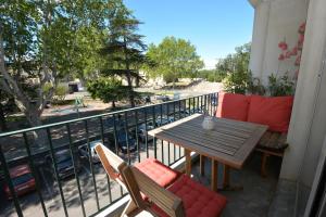 a balcony with a table and chairs and a view of a street at Appartement Tarascon avec garage privé in Tarascon