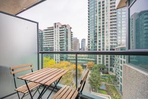 uma varanda com uma mesa de madeira e 2 cadeiras em Fort York Apartments em Toronto
