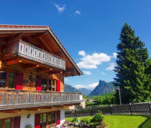 翁特拉梅爾高的住宿－Wohnung Grün - Ferienhaus Ammergau，带阳台的度假屋,享有山脉背景