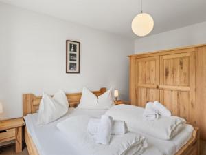 um quarto com 2 camas com lençóis brancos e toalhas em Apartment Kulm 2 by Interhome em Valbella
