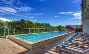 a large swimming pool with a row of chairs around it at Estelar Villavicencio Hotel & Centro De Convenciones in Villavicencio