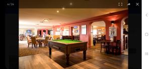 a room with a pool table and a dining room at Crandley Manor Lodge in Whitstable