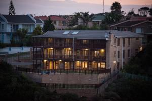 a large house with lights on in a city at Muzuri Apartment in Jeffreys Bay