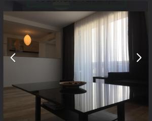 a living room with a table and a window at 4 RENT - Apt 3 camere in Constanţa